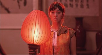 Movie still from “Raise the Red Lantern” (1991), directed by Yimou Zhang – A woman holding a lamp in her hand; Medium shot, Low angle