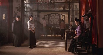 Movie still from “Raise the Red Lantern” (1991), directed by Yimou Zhang – A group of people standing in a room; Wide shot, Over the shoulder angle