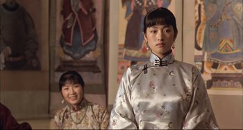 Movie still from “Raise the Red Lantern” (1991), directed by Yimou Zhang – Two women in traditional chinese clothing standing next to each other; Medium shot, Low angle