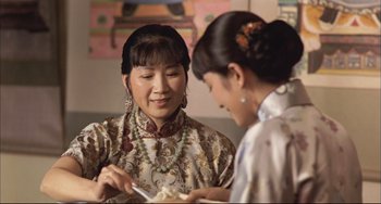 Movie still from “Raise the Red Lantern” (1991), directed by Yimou Zhang – Two asian women in traditional clothing eating food; Close Up shot, Over the shoulder angle