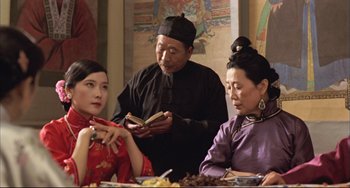 Movie still from “Raise the Red Lantern” (1991), directed by Yimou Zhang – A group of people sitting around a table; Medium shot, Over the shoulder angle