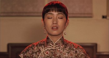 Movie still from “Raise the Red Lantern” (1991), directed by Yimou Zhang – A woman with her eyes closed with her eyes closed; Close Up shot, Low angle