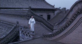 Movie still from “Raise the Red Lantern” (1991), directed by Yimou Zhang – A woman standing on the roof of an old building; Extreme Wide shot, Low angle