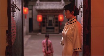 Movie still from “Raise the Red Lantern” (1991), directed by Yimou Zhang – A woman standing in front of another woman in front of a building; Medium shot, Over the shoulder angle