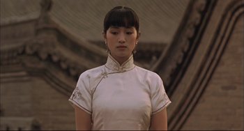 Movie still from “Raise the Red Lantern” (1991), directed by Yimou Zhang – A woman in a white dress standing in front of a wall; Close Up shot, Low angle