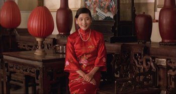 Movie still from “Raise the Red Lantern” (1991), directed by Yimou Zhang – A woman in a red dress sitting in a room; Medium shot, Low angle