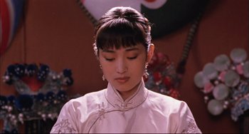 Movie still from “Raise the Red Lantern” (1991), directed by Yimou Zhang – A woman in a white dress is looking down at her face; Close Up shot, Low angle