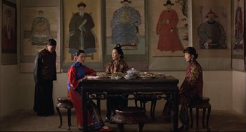 Movie still from “Raise the Red Lantern” (1991), directed by Yimou Zhang – A group of people sitting at a table with plates of food; Wide shot, High angle