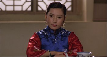 Movie still from “Raise the Red Lantern” (1991), directed by Yimou Zhang – A woman in a red and blue dress sitting in front of a window; Close Up shot, Low angle