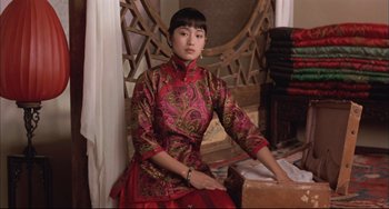 Movie still from “Raise the Red Lantern” (1991), directed by Yimou Zhang – A woman sitting on the ground wearing a red dress; Medium shot, High angle