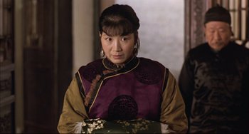 Movie still from “Raise the Red Lantern” (1991), directed by Yimou Zhang – A woman in a purple and yellow jacket; Close Up shot, Over the shoulder angle