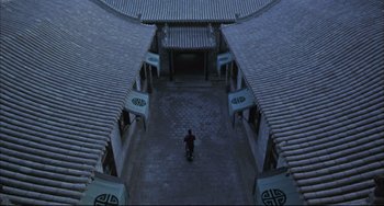 Movie still from “Raise the Red Lantern” (1991), directed by Yimou Zhang – A man riding a scooter down the middle of a courtyard; Extreme Wide shot, High angle