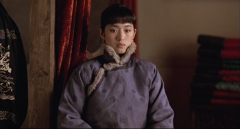 Movie still from “Raise the Red Lantern” (1991), directed by Yimou Zhang – A young woman in a purple coat with a fur collar; Medium shot, Over the shoulder angle
