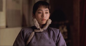 Movie still from “Raise the Red Lantern” (1991), directed by Yimou Zhang – A young woman wearing a purple coat and a fur collar; Close Up shot, Over the shoulder angle