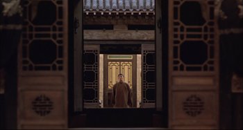 Movie still from “Raise the Red Lantern” (1991), directed by Yimou Zhang – A man standing in front of an open door; Wide shot, Low angle