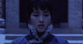 Movie still from “Raise the Red Lantern” (1991), directed by Yimou Zhang – A young woman wearing a blue jacket with a white fur collar; Close Up shot, Low angle
