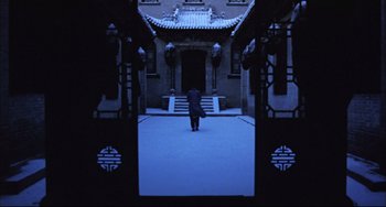 Movie still from “Raise the Red Lantern” (1991), directed by Yimou Zhang – A person standing in front of an entrance to a building; Extreme Wide shot, High angle