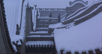 Movie still from “Raise the Red Lantern” (1991), directed by Yimou Zhang – A person walking down a snow covered staircase; Extreme Wide shot, Low angle