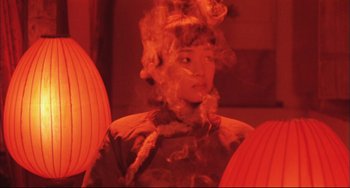 Movie still from “Raise the Red Lantern” (1991), directed by Yimou Zhang – A woman with smoke coming out of her face; Medium shot, Low angle