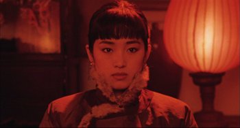 Movie still from “Raise the Red Lantern” (1991), directed by Yimou Zhang – A young woman with bangs wearing a fur coat; Close Up shot, Low angle