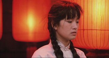 Movie still from “Raise the Red Lantern” (1991), directed by Yimou Zhang – A young woman with long hair is looking down; Close Up shot, Low angle