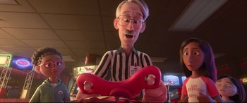 Movie still from “Ralph Breaks the Internet” (2018), directed by Rich Moore – An old man holding a steering wheel in a video game room; Medium shot, High angle