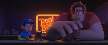 Movie still from “Ralph Breaks the Internet” (2018), directed by Rich Moore – A person sitting at a table with a glass of root beer in front of him; Medium shot, Over the shoulder angle