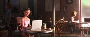 Movie still from “Ralph Breaks the Internet” (2018), directed by Rich Moore – A young girl sitting at a table with a laptop computer; Medium shot, Over the shoulder angle