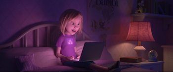 Movie still from “Ralph Breaks the Internet” (2018), directed by Rich Moore – A little girl sitting on a bed using a laptop computer; Wide shot, Over the shoulder angle