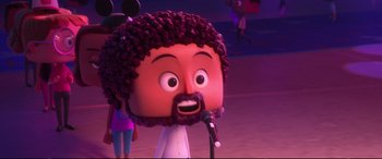 Movie still from “Ralph Breaks the Internet” (2018), directed by Rich Moore – A cartoon of a person with a beard and a microphone; Close Up shot, Over the shoulder angle