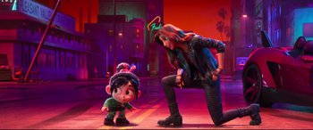 Movie still from “Ralph Breaks the Internet” (2018), directed by Rich Moore – A woman standing next to an animated character on a stage; Wide shot, Over the shoulder angle
