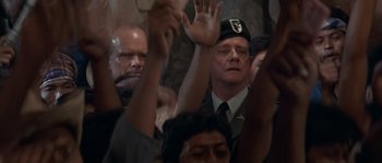 Movie still from “Rambo III” (1988), directed by Peter MacDonald – A group of people raising their hands in the air; Close Up shot, Low angle
