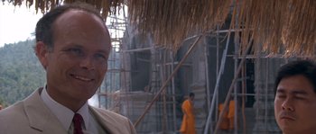 Movie still from “Rambo III” (1988), directed by Peter MacDonald – A man standing in front of a building under construction; Close Up shot, Low angle