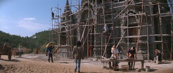 Movie still from “Rambo III” (1988), directed by Peter MacDonald – A group of people standing on top of scaffolding; Extreme Wide shot, Low angle