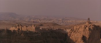 Movie still from “Rambo III” (1988), directed by Peter MacDonald – A view of a mountain range with a castle in the foreground; Extreme Wide shot, High angle