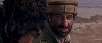 Movie still from “Rambo III” (1988), directed by Peter MacDonald – A person wearing a hat; Close Up shot, Over the shoulder angle