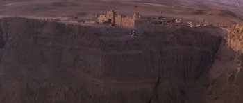 Movie still from “Rambo III” (1988), directed by Peter MacDonald – An aerial view of an abandoned castle in the middle of the desert; Extreme Wide shot, High angle