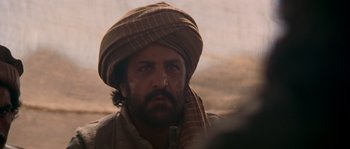 Movie still from “Rambo III” (1988), directed by Peter MacDonald – A person wearing a turban; Close Up shot, Over the shoulder angle