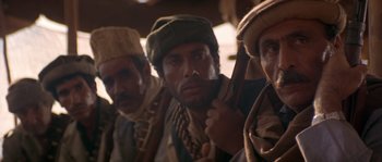 Movie still from “Rambo III” (1988), directed by Peter MacDonald – A group of men standing next to each other; Close Up shot, Low angle