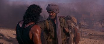Movie still from “Rambo III” (1988), directed by Peter MacDonald – A man with a turban on a mountain side; Medium shot, Over the shoulder angle