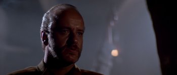 Movie still from “Rambo III” (1988), directed by Peter MacDonald – A man with a beard is looking into the distance; Close Up shot, Low angle