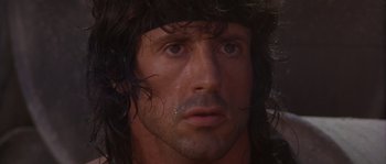 Movie still from “Rambo III” (1988), directed by Peter MacDonald – A person with long black hair; Close Up shot, Low angle