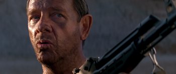 Movie still from “Rambo III” (1988), directed by Peter MacDonald – A person holding a gun; Close Up shot, Low angle