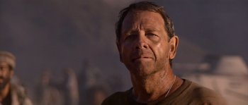 Movie still from “Rambo III” (1988), directed by Peter MacDonald – A person wearing a brown t - shirt; Close Up shot, Low angle