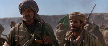 Movie still from “Rambo III” (1988), directed by Peter MacDonald – A group of men standing next to each other on top of a hill; Close Up shot, Low angle