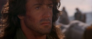 Movie still from “Rambo III” (1988), directed by Peter MacDonald – A person with long hair; Close Up shot, Over the shoulder angle