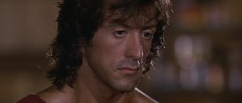 Movie still from “Rambo: First Blood Part II” (1985), directed by George P. Cosmatos – A man's face in a movie scene; Close Up shot, Over the shoulder angle