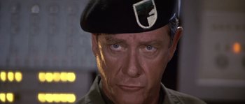 Movie still from “Rambo: First Blood Part II” (1985), directed by George P. Cosmatos – A person wearing a hat; Close Up shot, Low angle