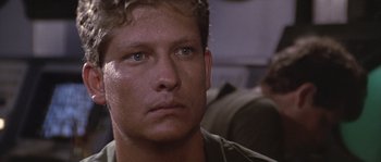 Movie still from “Rambo: First Blood Part II” (1985), directed by George P. Cosmatos – A person wearing a green shirt; Close Up shot, Low angle