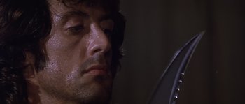 Movie still from “Rambo: First Blood Part II” (1985), directed by George P. Cosmatos – A man's face in a mirror; Close Up shot, Low angle